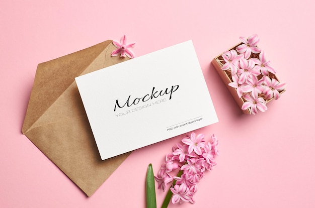 Mockup di invito o biglietto di auguri con busta e fiori rosa nella casella