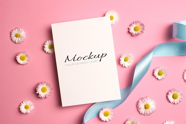 Invitation or greeting card mockup with ribbon and daisy flowers on pink