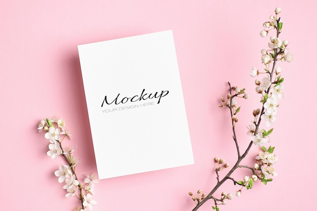 Invitation or greeting card mockup with spring cherry blossom flowers twigs