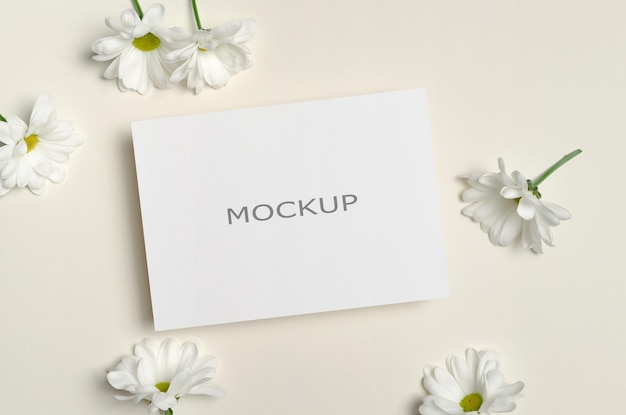 Invitation or greeting card mockup with white chamomile flowers