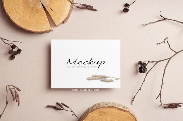Invitation or greeting card sationary mockup with dry tree twigs and cut log decorations