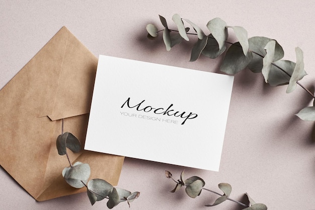 Invitation or greeting card stationary mockup with envelope and dry eucalyptus twigs