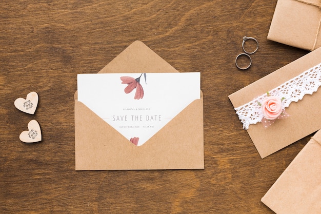 PSD invitation mock-up and wedding rings on wooden background