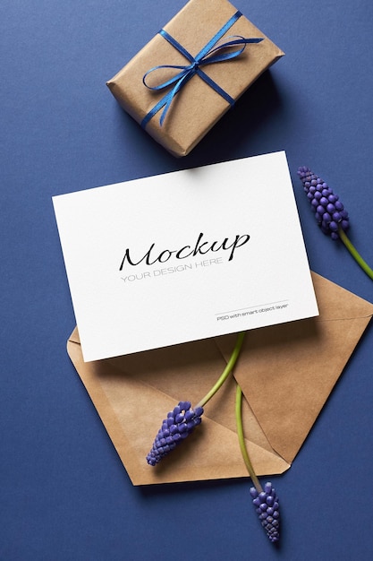 Макет приглашения или поздравительной открытки с подарочной коробкой, конвертом и синими цветами мускари