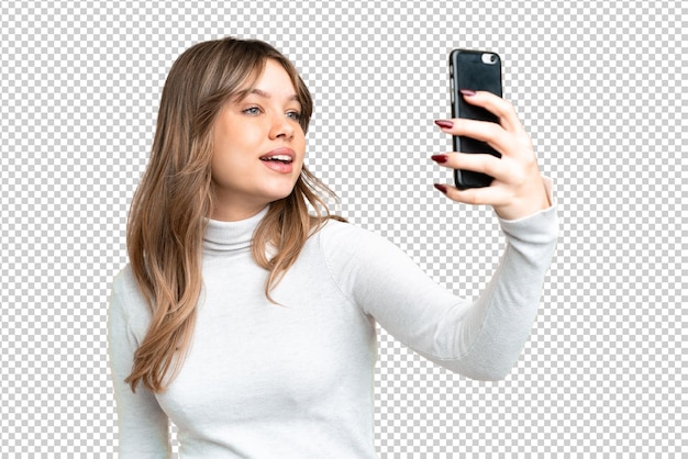 Jong meisje met een geïsoleerde chroma-sleutel achtergrond die een selfie maakt met een mobiele telefoon
