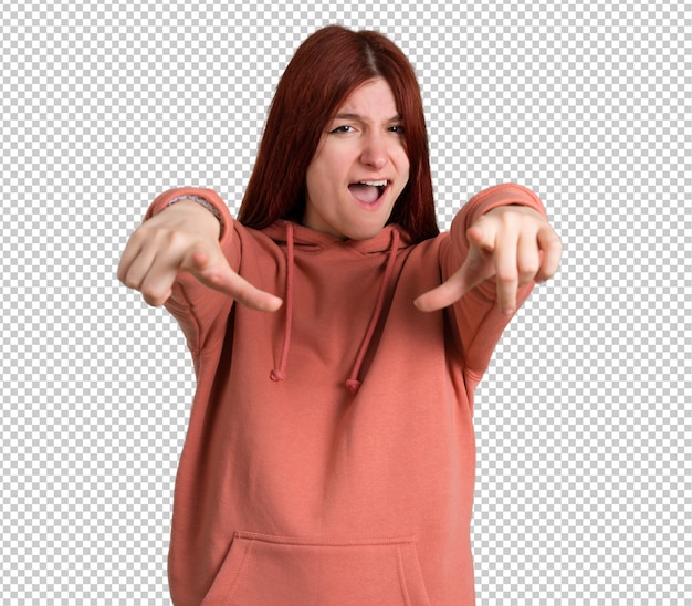 Jong roodharigemeisje met roze sweatshirt die met vinger op iemand richten en veel lachen