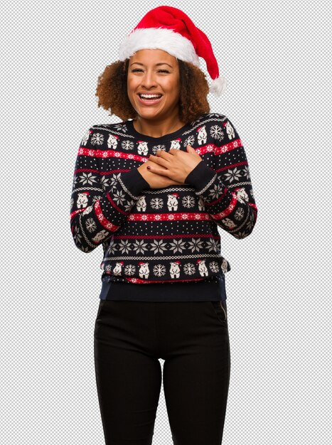 Jong zwarte in een trendy kerstmissweater met druk die een romantisch gebaar doet