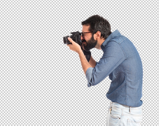 Jonge hipstermens die over witte achtergrond fotografeert