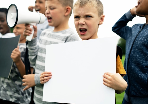 Jonge jongen die een leeg document in een protest toont