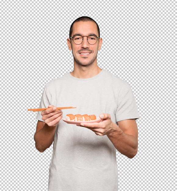 Jonge man met stokjes om sushi te eten