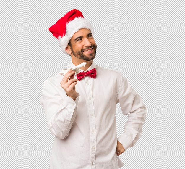 Jonge mens die een hoed van de Kerstman op Kerstdag draagt