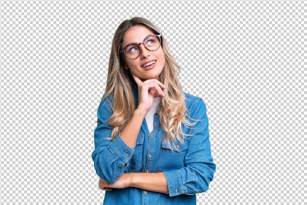 Jonge Uruguayaanse vrouw over een geïsoleerde achtergrond die naar boven kijkt terwijl ze glimlacht
