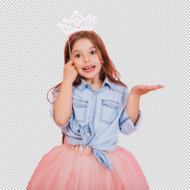 긴 갈색 머리카락을 가진 기쁜 어린 소녀는 리 치마를 입고 머리에 공주 왕관을 들고 분홍색 배경에 고립되어 생일 파티의 긍정성을 표현하는 어린이들을위한 밝은 카니발을 축하합니다.