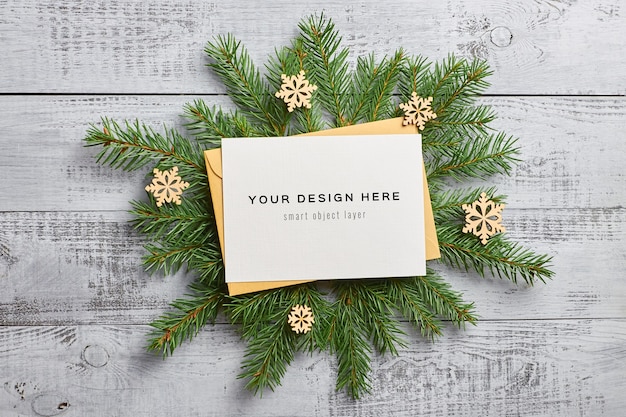 Kerst wenskaart mockup met dennentakken en houten decoraties