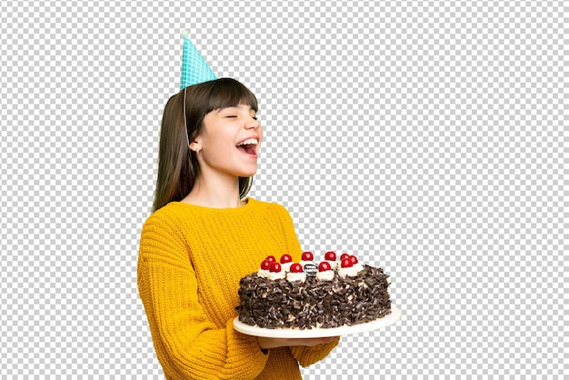 Klein meisje met verjaardagstaart over een geïsoleerde chroma-sleutel achtergrond lacht in een zijdelingse positie