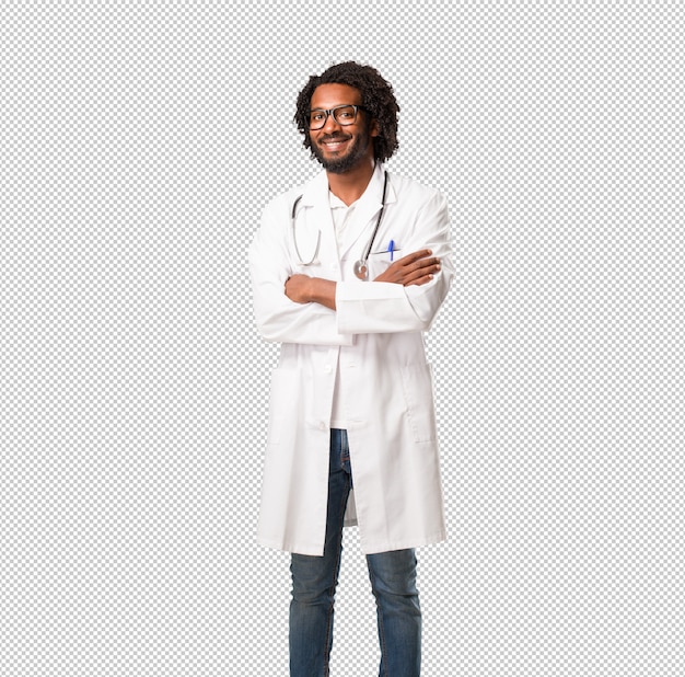 Knappe Afro-Amerikaanse arts zijn armen oversteken, glimlachen en gelukkig, zelfverzekerd en vriendelijk