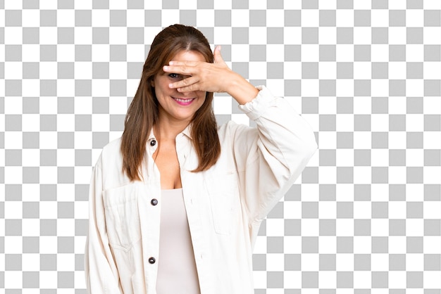 PSD kobieta w średnim wieku na odosobnionym tle zakrywa oczy rękami i uśmiecha się
