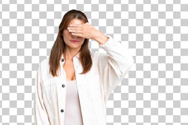PSD kobieta w średnim wieku na odosobnionym tle zakrywa oczy rękami nie chce widzieć czegoś
