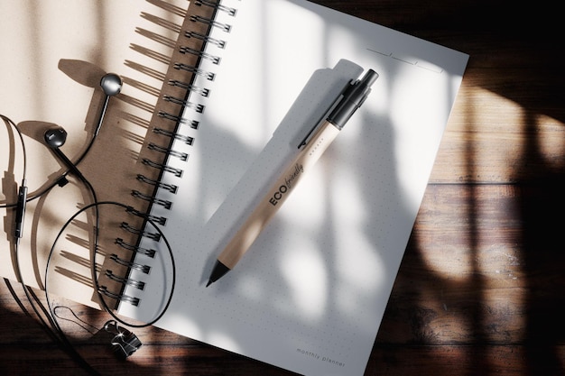 Kraft pen on open notepad with headphones mockup