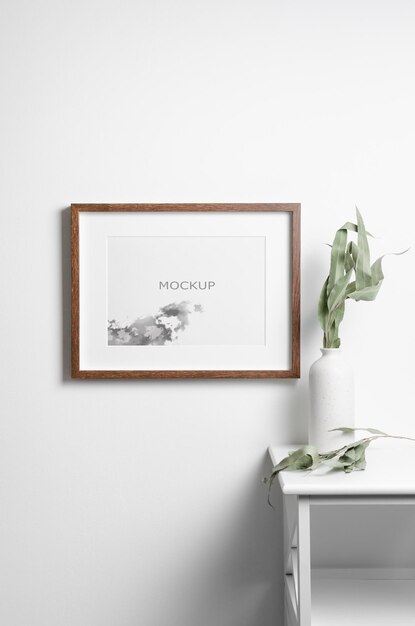 PSD landscape wooden frame mockup on white wall with dry eucalyptus