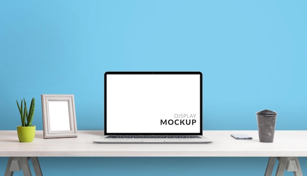 Laptop computer mockup on clean work desk with blue background