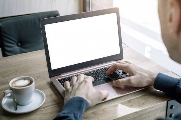 laptop mockup for app or web site design promotion. the guy in the caffee uses a laptop typing on a keyboard. cup of coffee beside