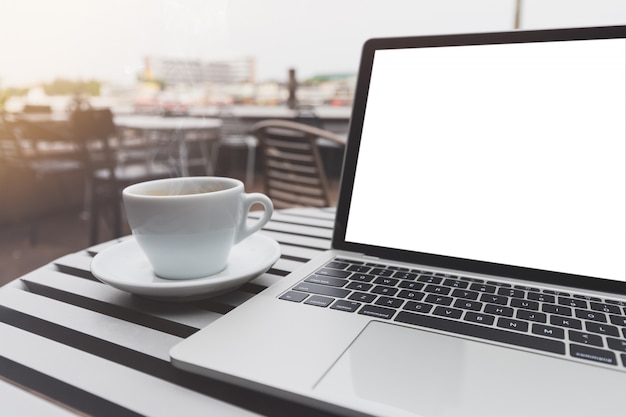 Laptop mockup and hot espresso in coffee shop