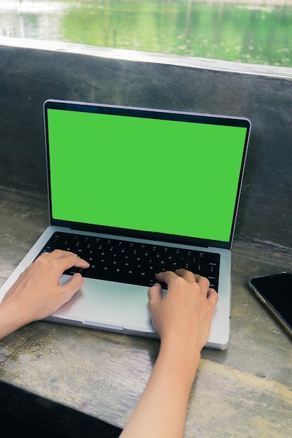 Laptop mockup met groen scherm Handen typen buiten Betonnen tafel