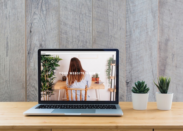 Laptop mockup op tafel met planten