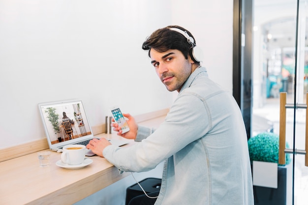 Laptop mockup with man wearing headphones