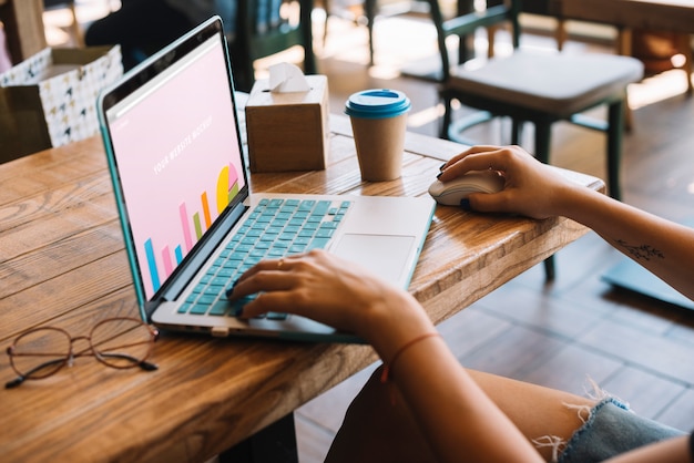 PSD laptop mockup with woman on wooden table