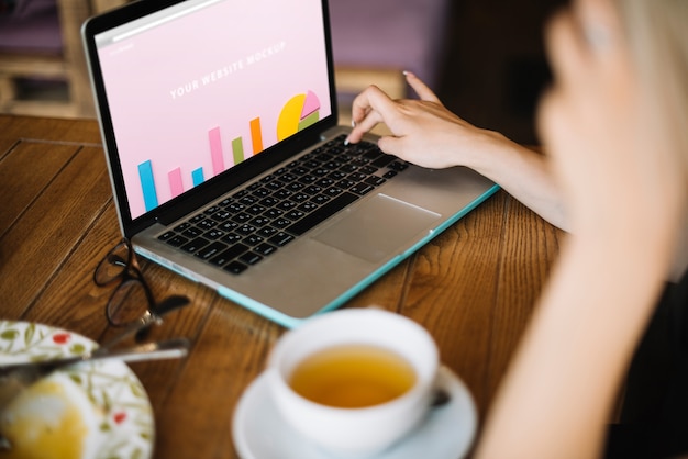 PSD laptop mockup with woman on wooden table