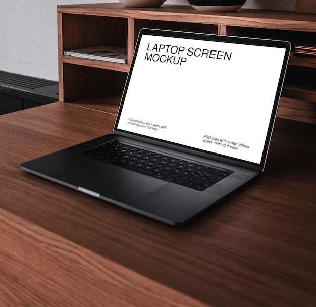 Laptop na ciemnobrązowym drewnianym stole