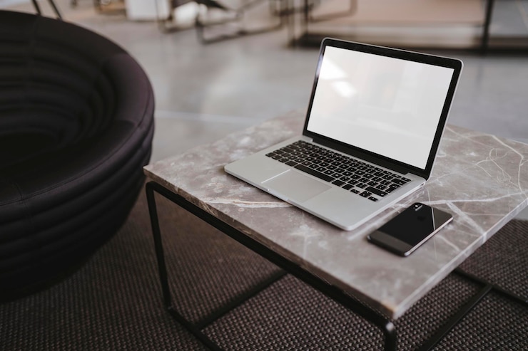 PSD laptop and a phone on a marble table