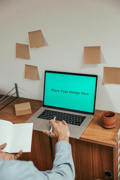 laptop with mans hand and pen psd mockup for professional workspace branding