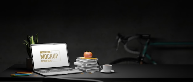 Laptop z makietą ekranu i stosem książek