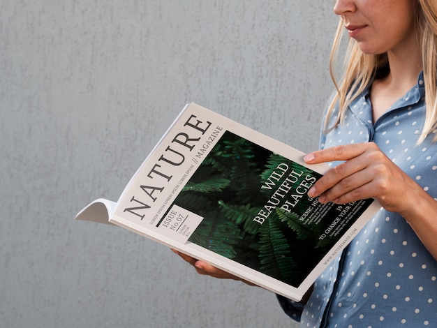 PSD lateral view woman holding a nature magazine