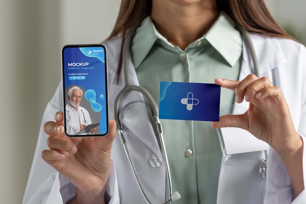 Lekarz kliniki trzymający makietę telefonu i wizytówki