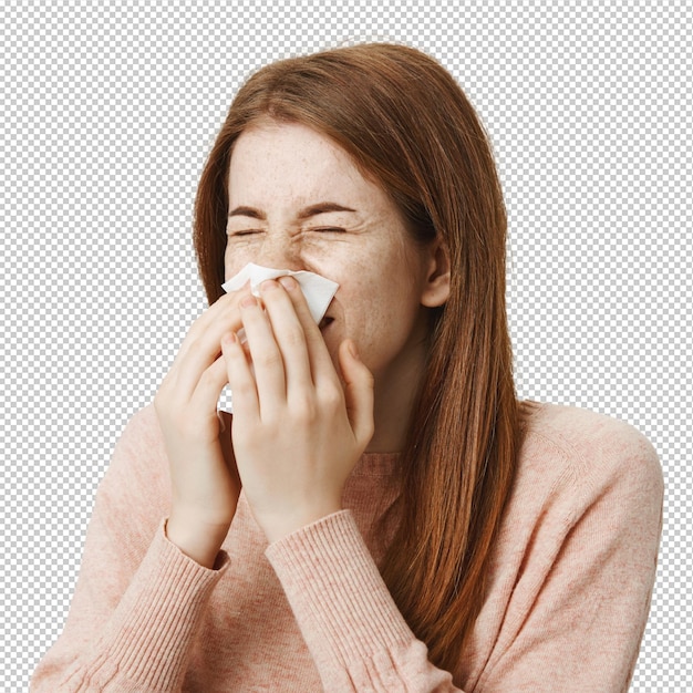Leuk, ziek roodharig meisje met een allergie die niezt in een servet.