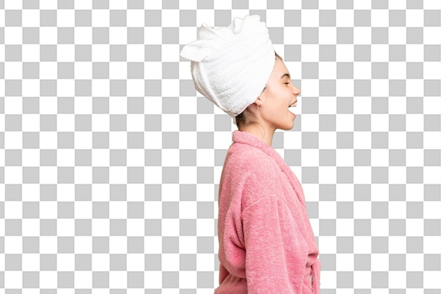 little girl in a bathrobe over isolated chroma key background laughing in lateral position