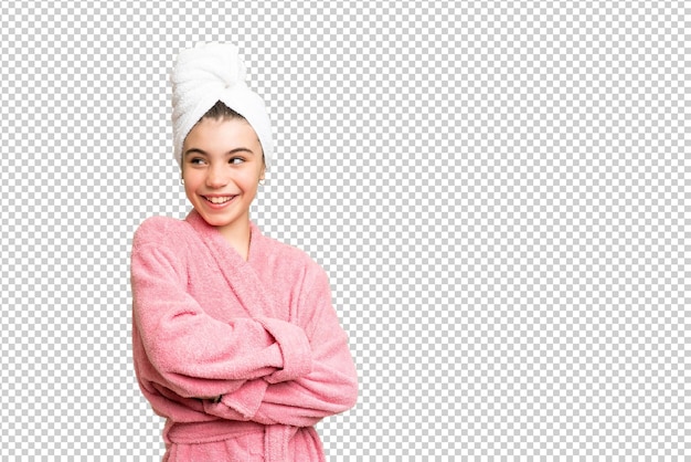 Little girl in a bathrobe over isolated chroma key background with arms crossed and happy