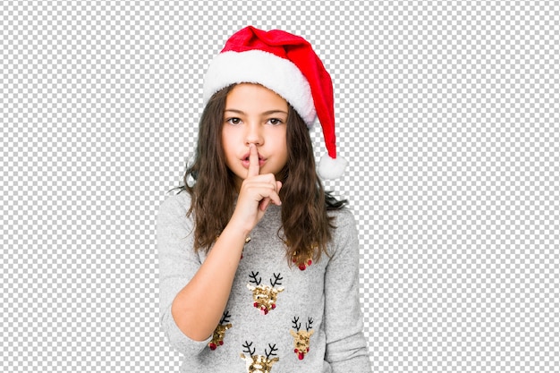 Little girl celebrating christmas day keeping a secret or asking for silence.