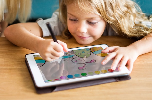 Little girl coloring on a tablet