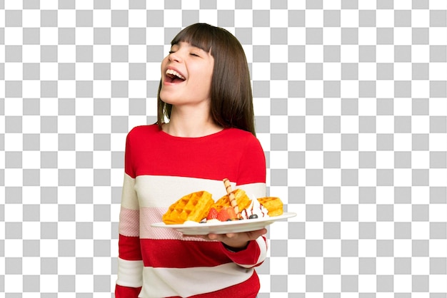 고립 된 크로마 키 배경에 와플을 들고 있는 작은 소녀 웃음