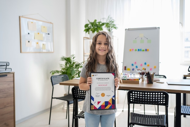 Little girl at home holding a certificate mock-up