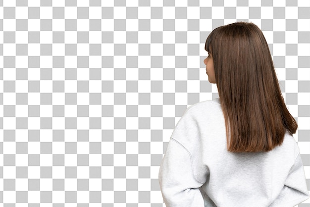 Little girl over isolated green chroma key background in back position and looking back
