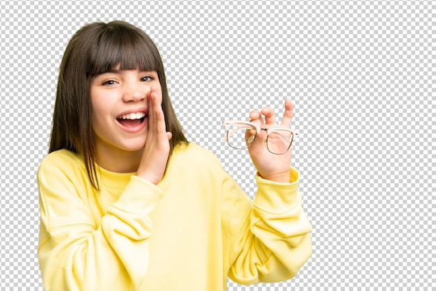隔離されたクロマキー背景の上にメガネをかぶった小さな女の子が何かをささやいている