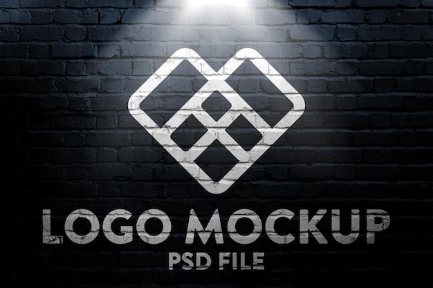 PSD mockup di logo su un muro di mattoni scuro con luce