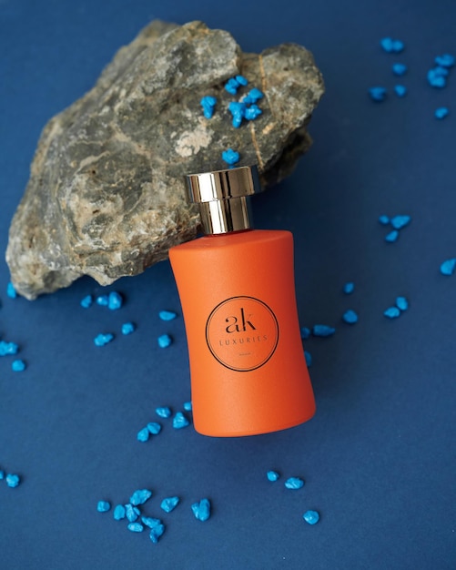 Logo mockup on an orange colored perfume bottle