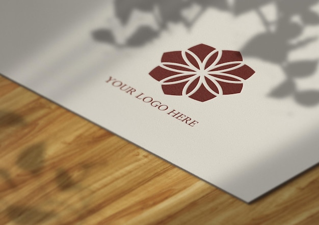 Presentazione del mockup del logo su carta e sfondo in legno